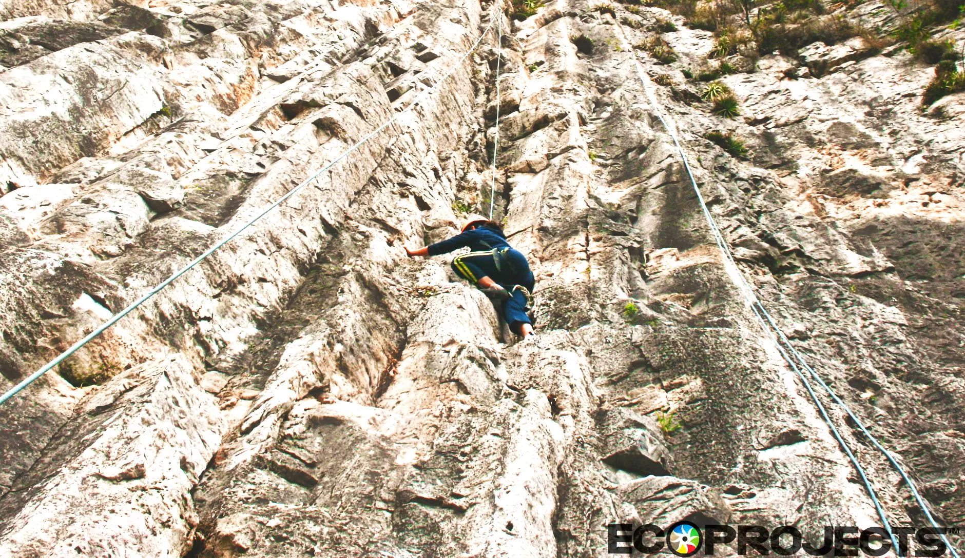Ecoproparks. Persona utilizando rapel para escalar montaña rocosa.
