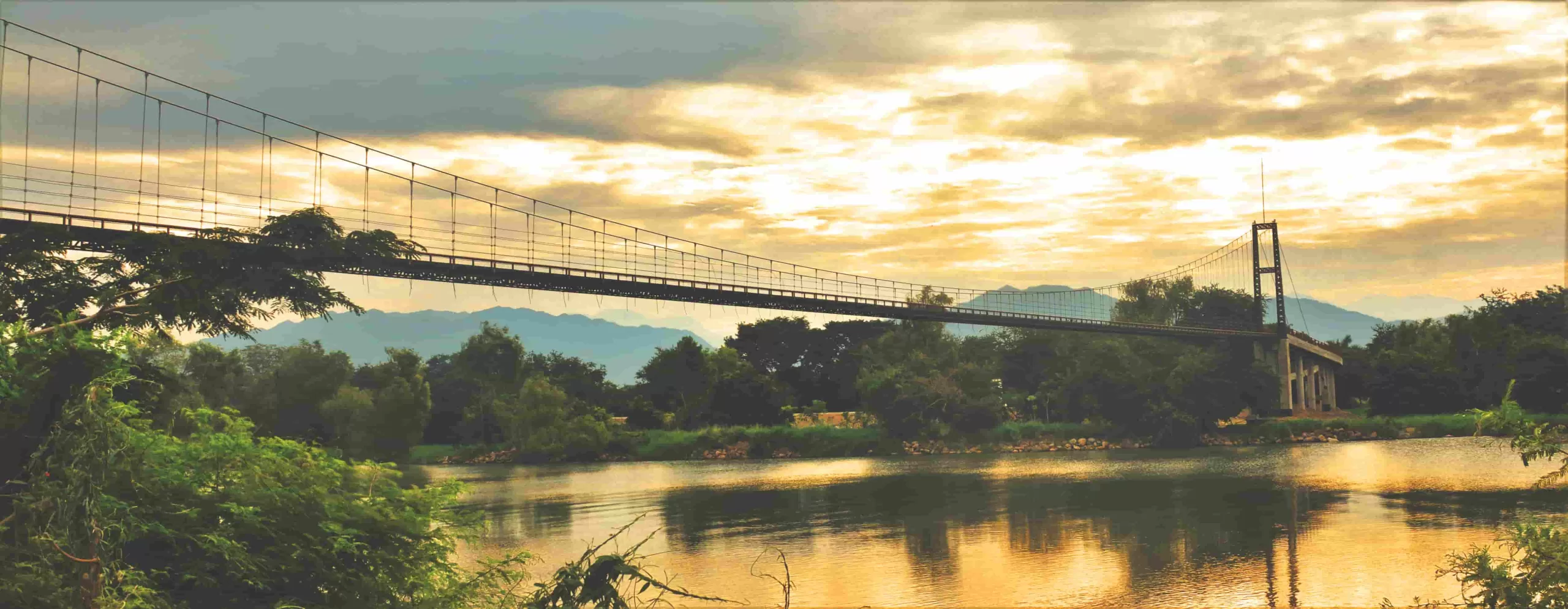 Ecoproparks. Un pintoresco puente de madera construido por Ecoproparks, que cruza un enorme lago tranquilo, ofreciendo una experiencia de conexión con la naturaleza.