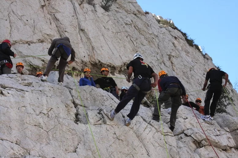 Ecoproparks. Personas usando rapel para bajar montaña rocosa.
